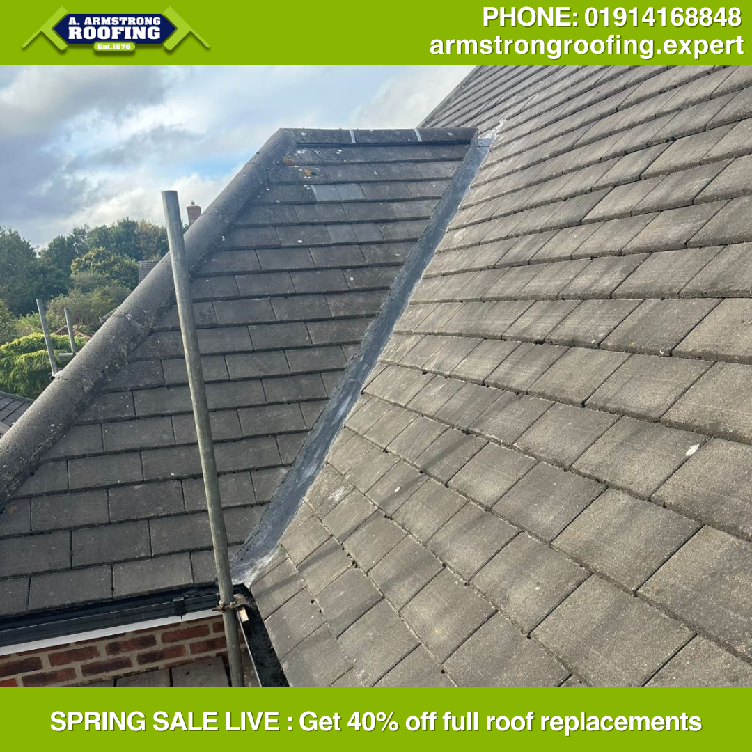 Close-up of newly installed grey tiled roof, displaying expert craftsmanship with secure ridge tiles and flashing, part of Armstrong Roofing's quality roof replacement services.