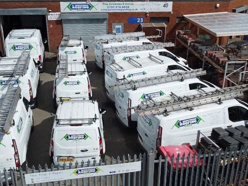 A. Armstrong Roofing unit with vans parked in the gates