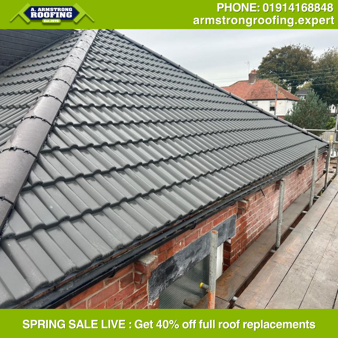 Side view of a completed pitched roof with sleek grey tiles and precise ridge capping on a red-brick home, showcasing Armstrong Roofing’s attention to detail.