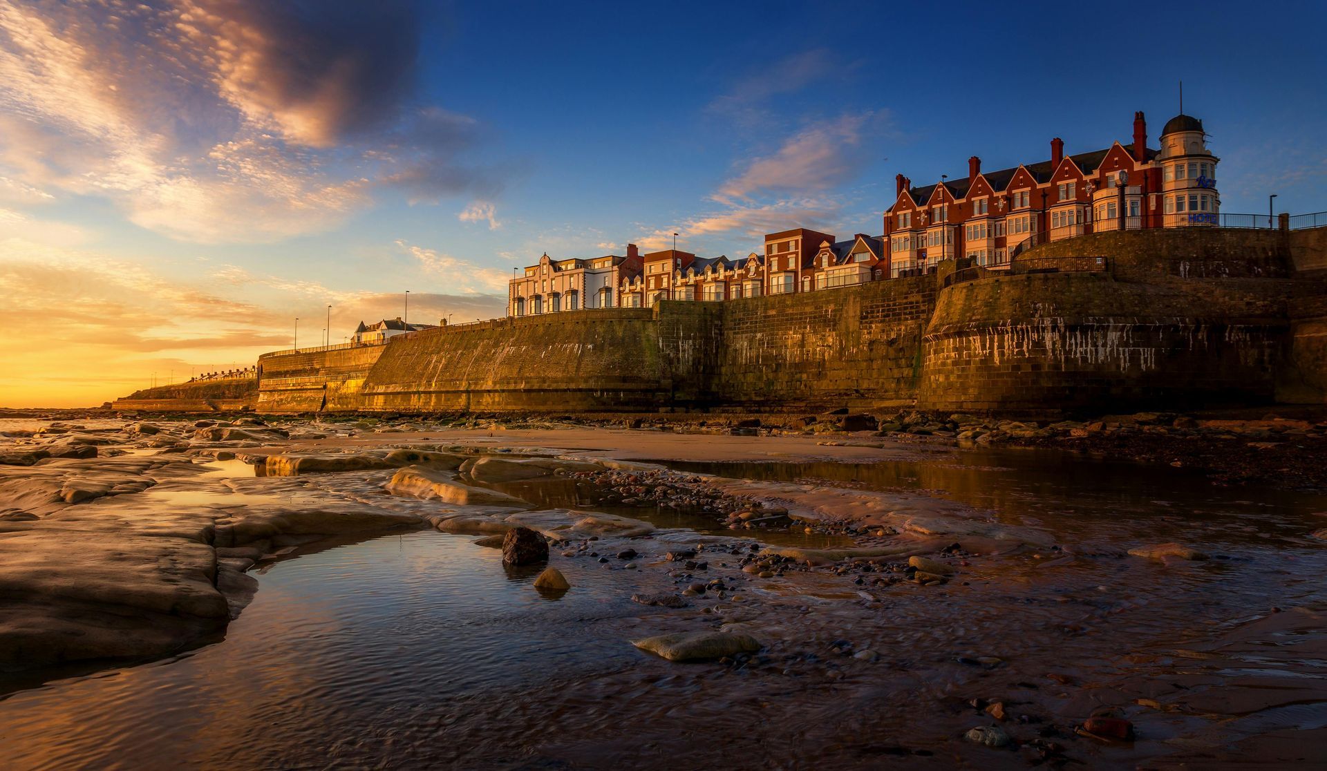 Tynemouth coastline at sunset, featuring historic seafront buildings and rocky shorelines — representing the areas covered by A. Armstrong Roofing’s services in North Tyneside.