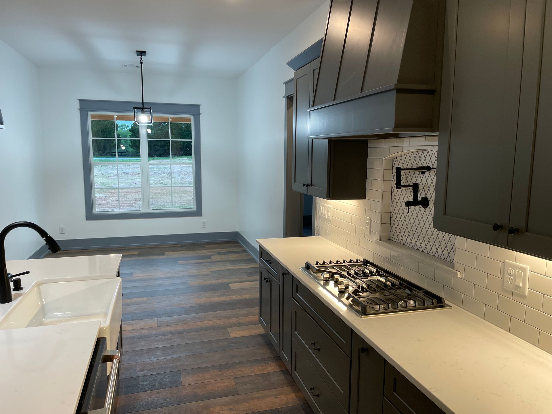 A kitchen with a stove top oven and a sink.