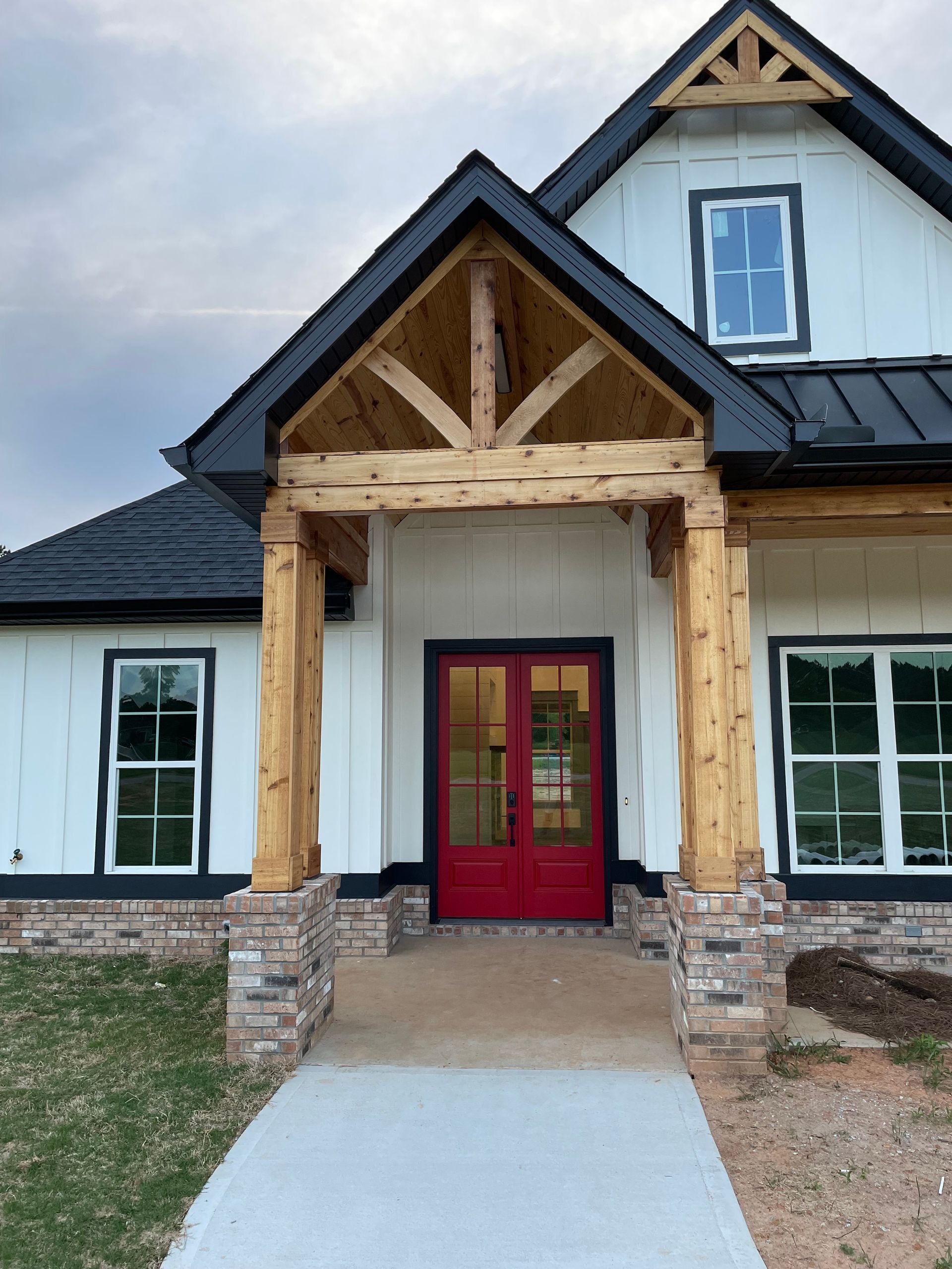 A white house with a black roof and a red door