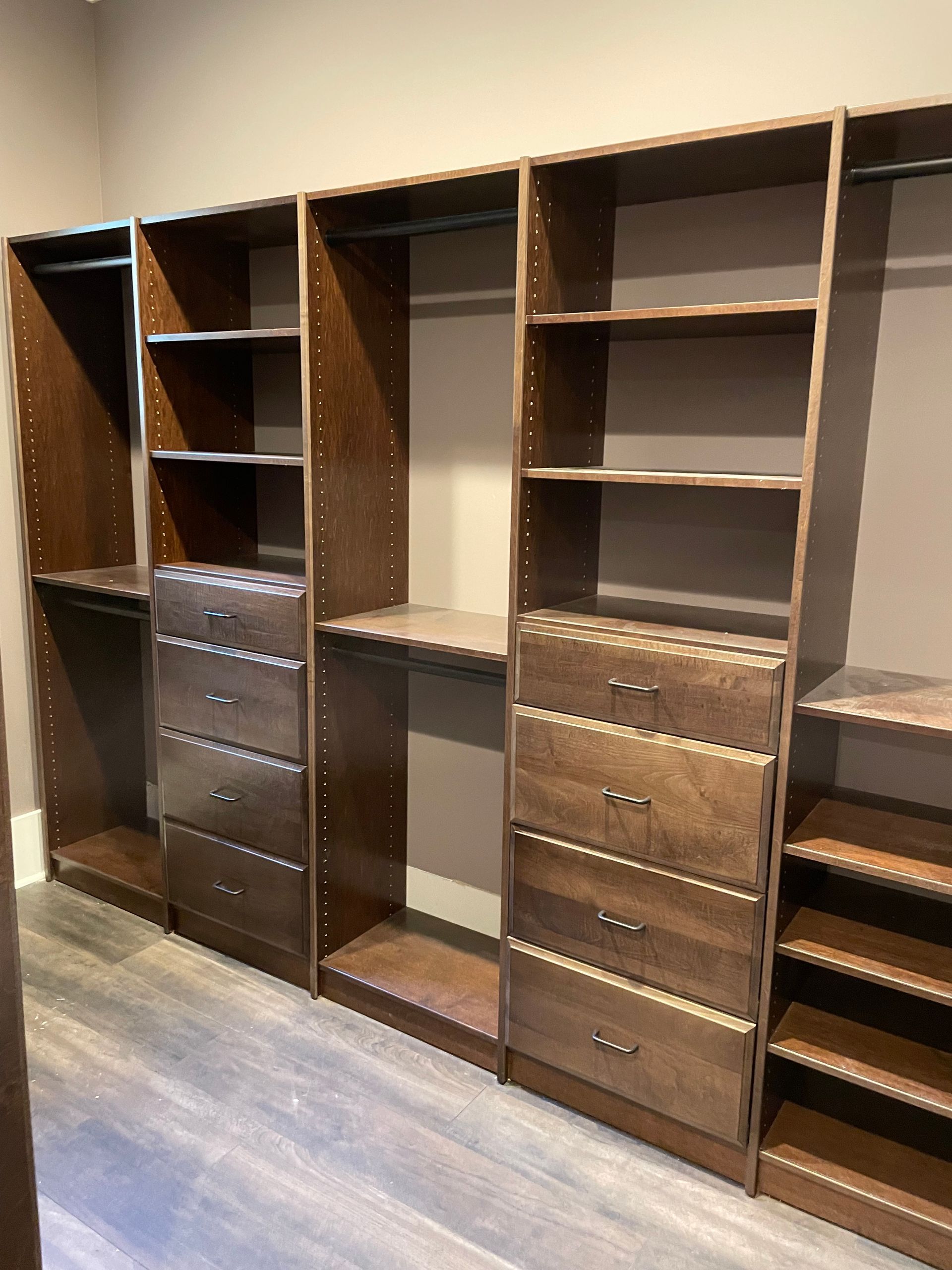 A walk in closet with lots of shelves and drawers