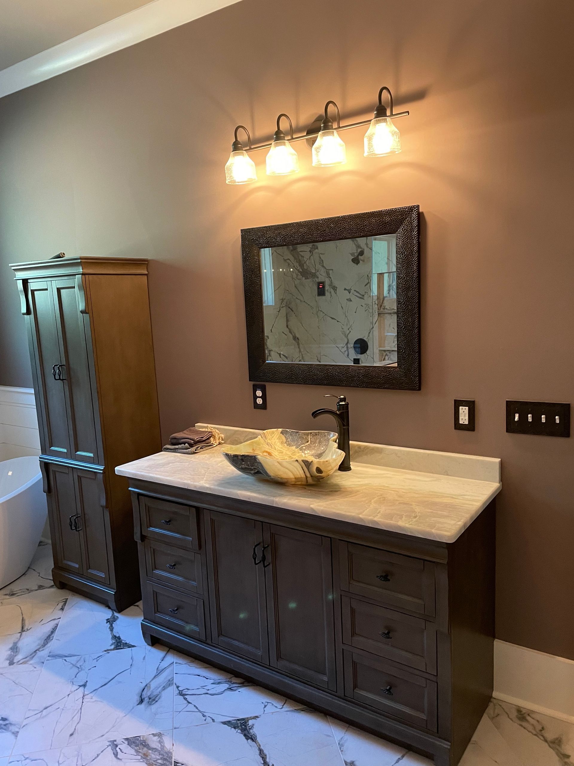 A bathroom with a sink , mirror and cabinets