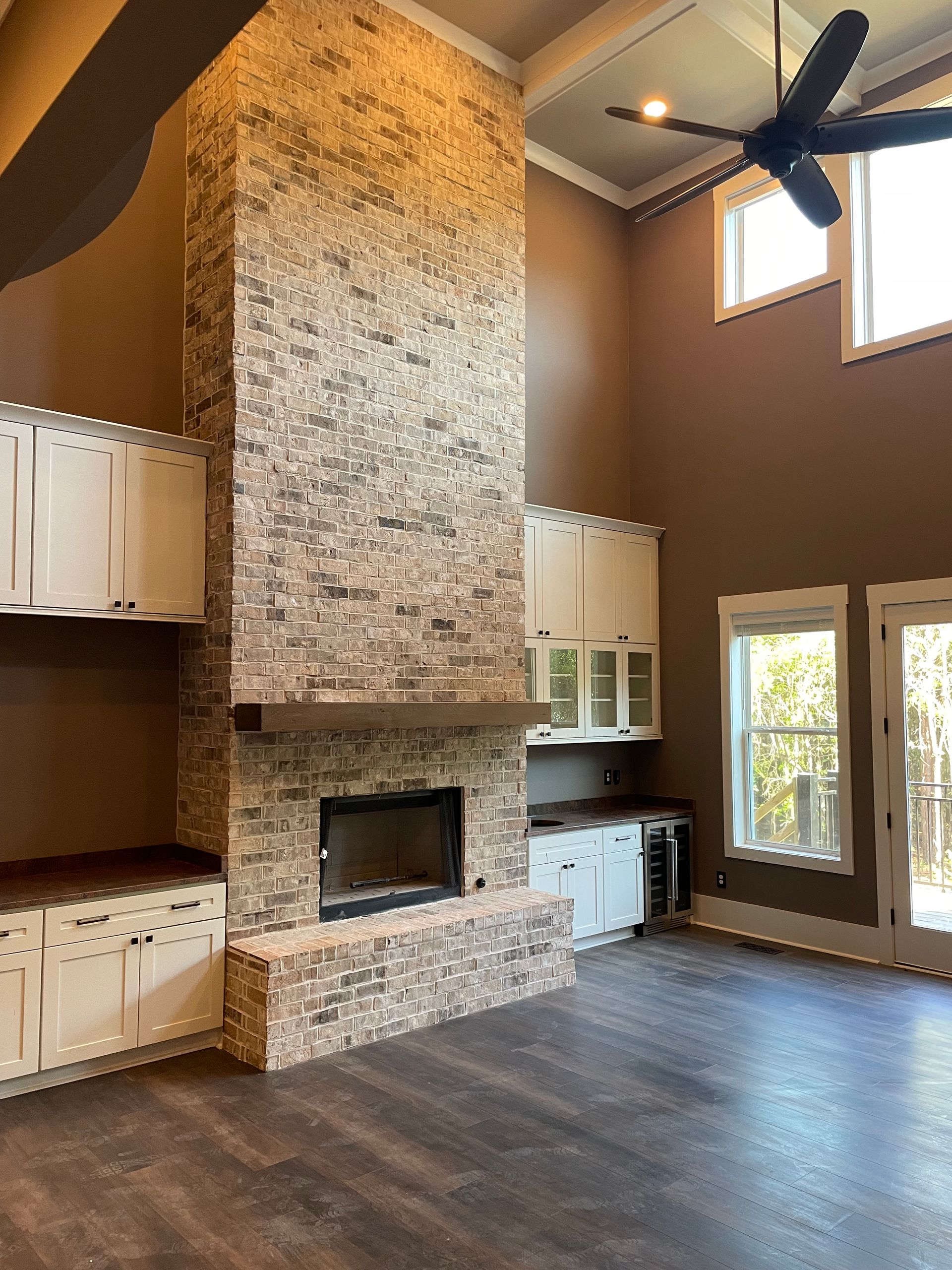 A living room with a fireplace and a ceiling fan.