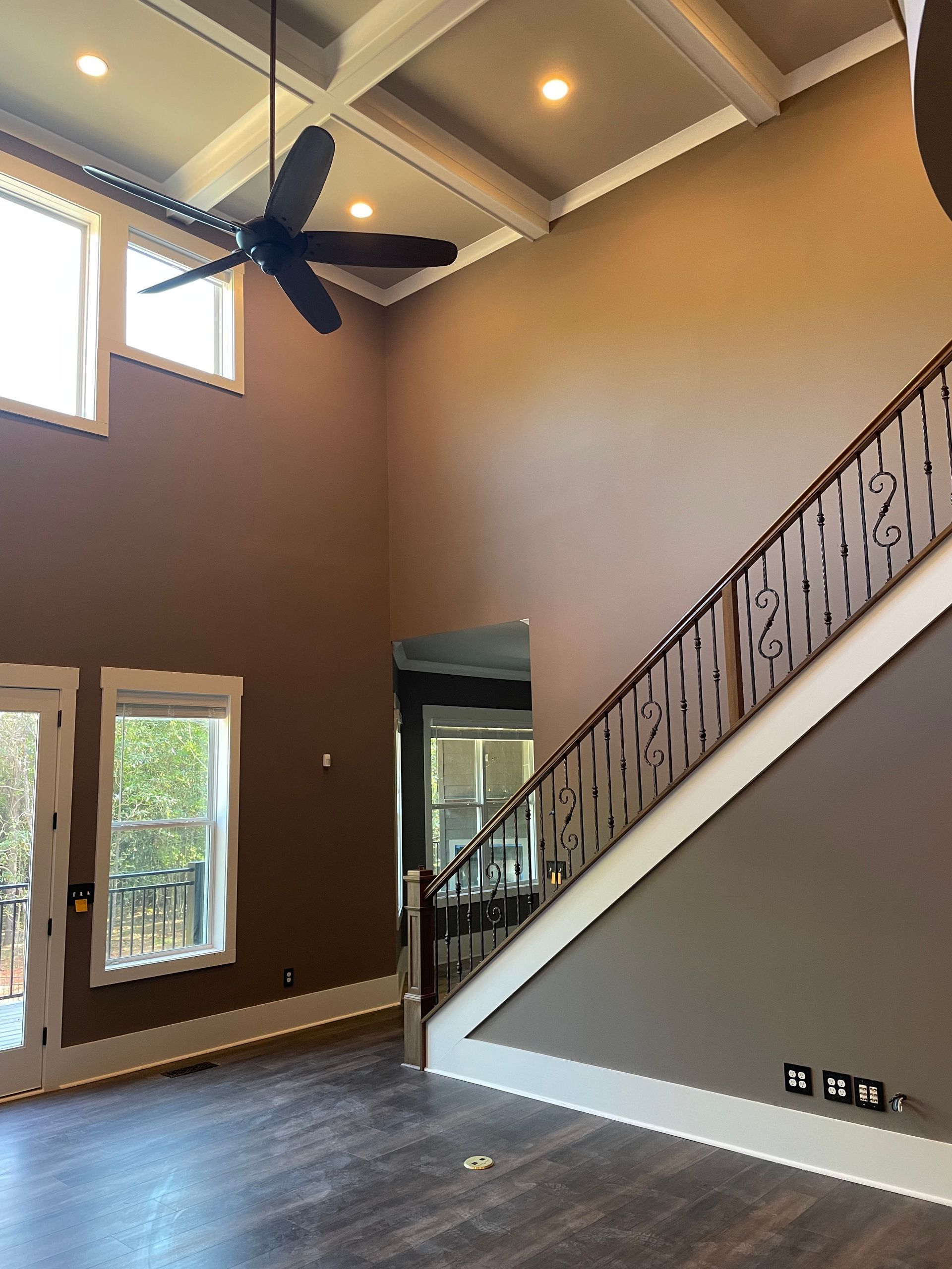 A living room with a staircase and a ceiling fan