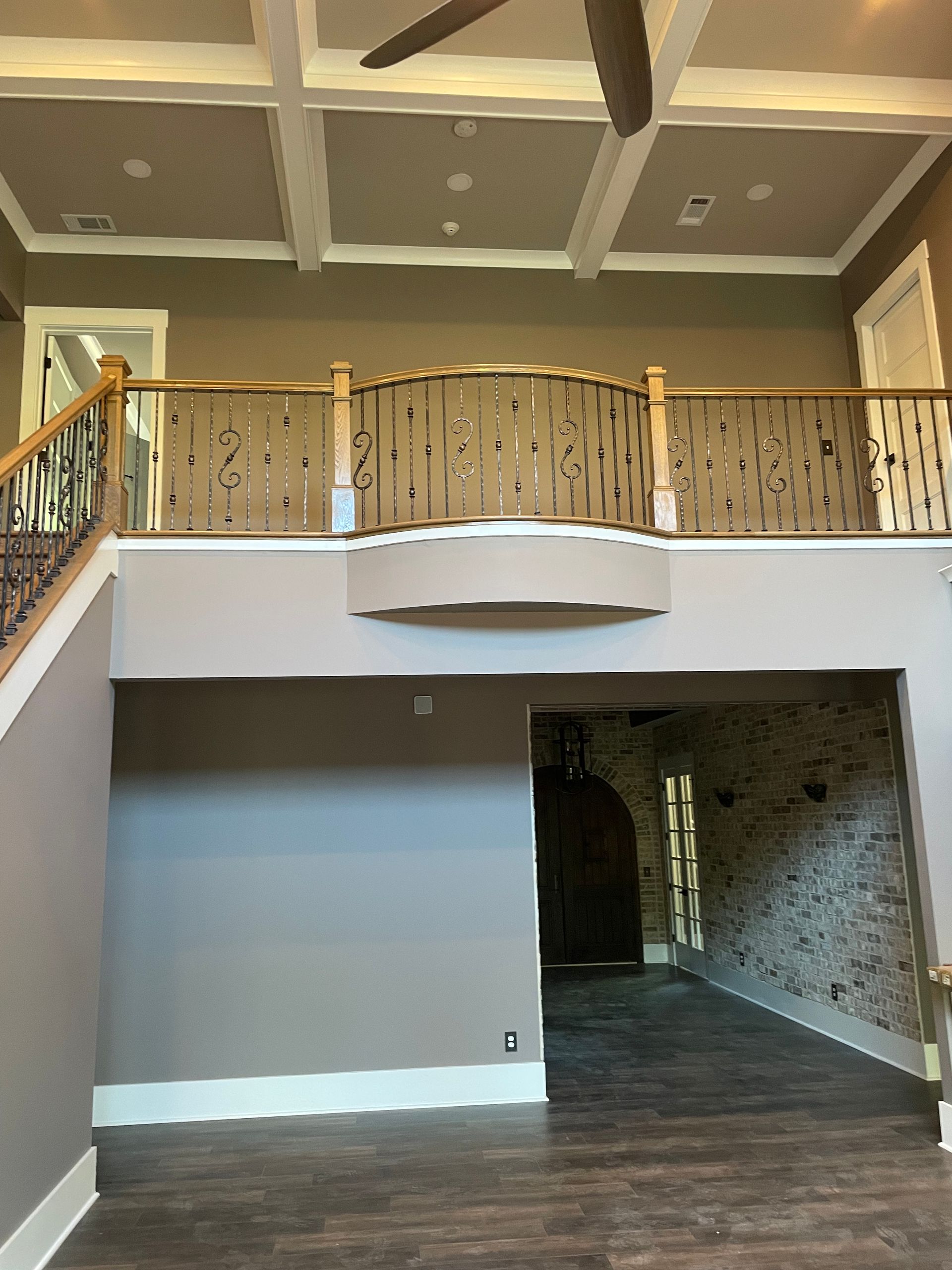 A living room with a balcony and a ceiling fan.