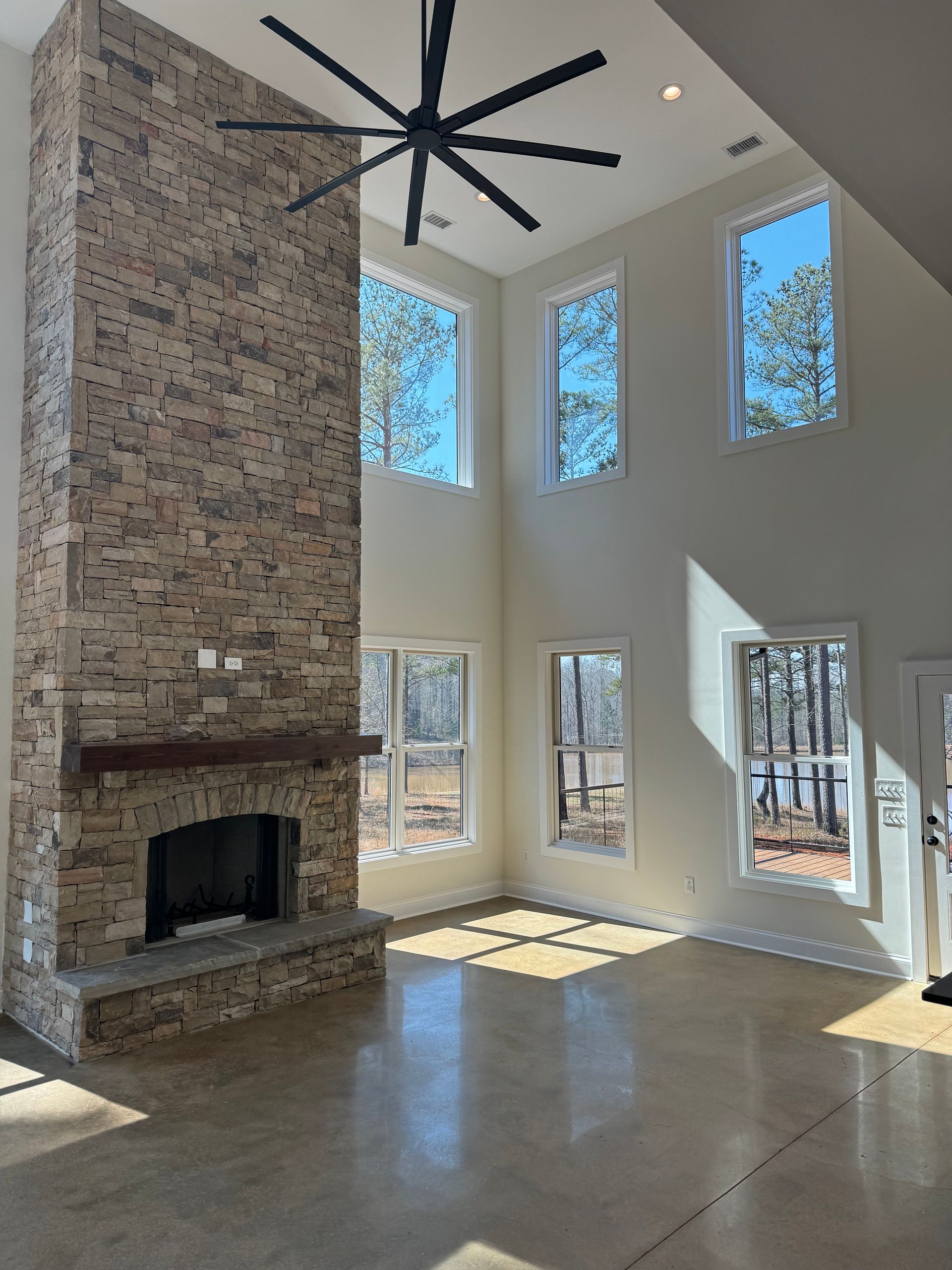 A living room with a fireplace and a ceiling fan