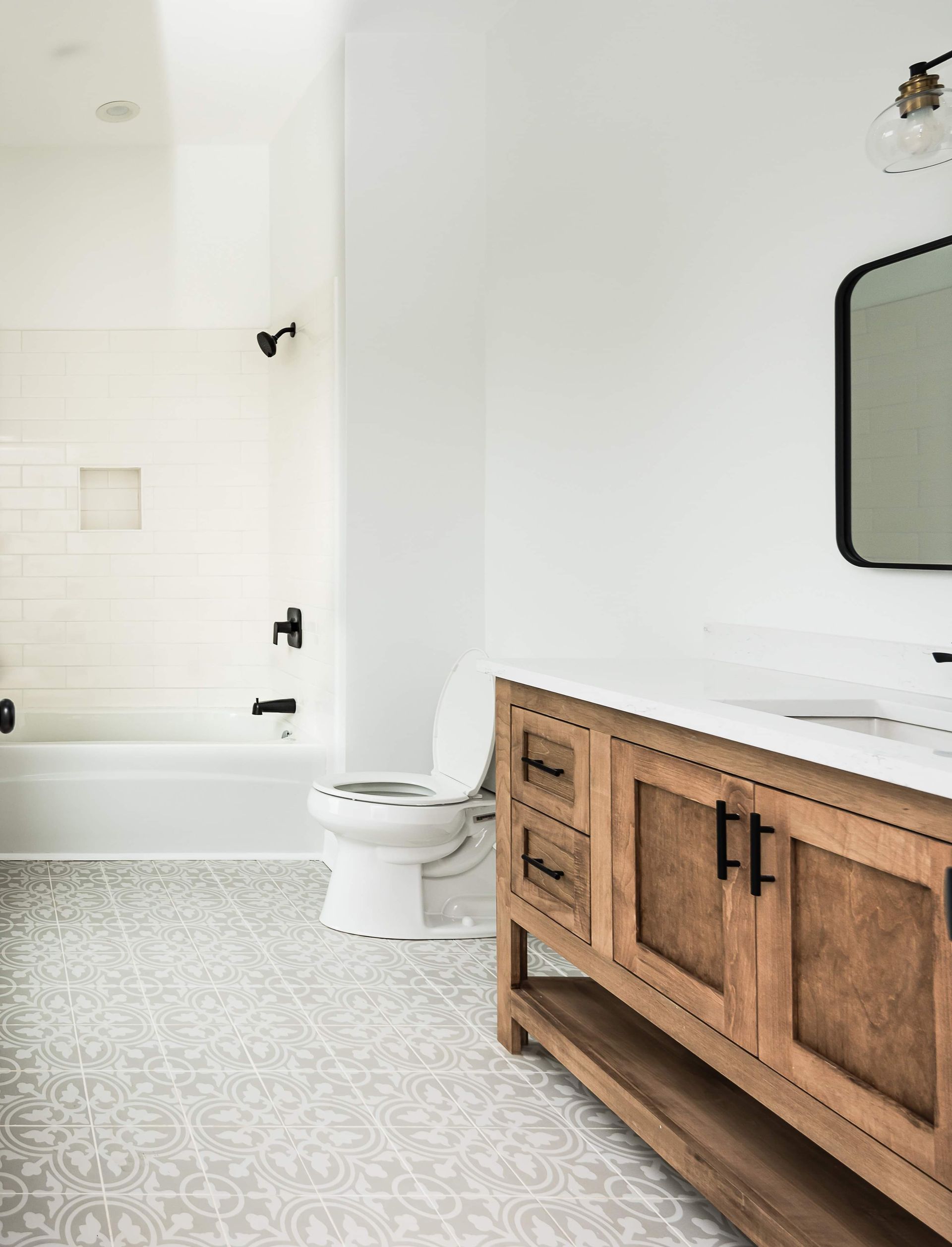 A bathroom with a toilet , sink , mirror and bathtub.