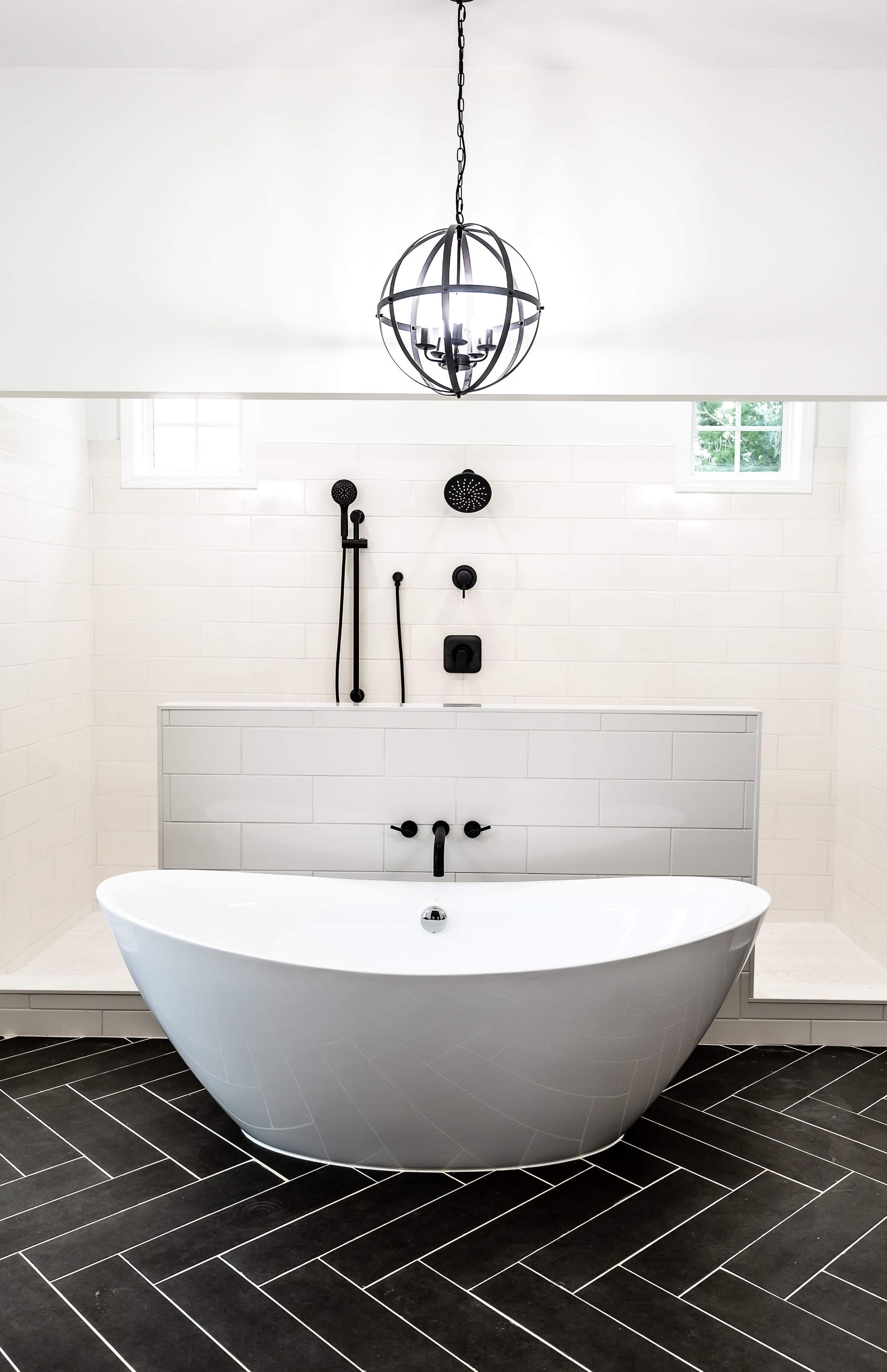 A bathroom with a bathtub and a chandelier hanging from the ceiling.