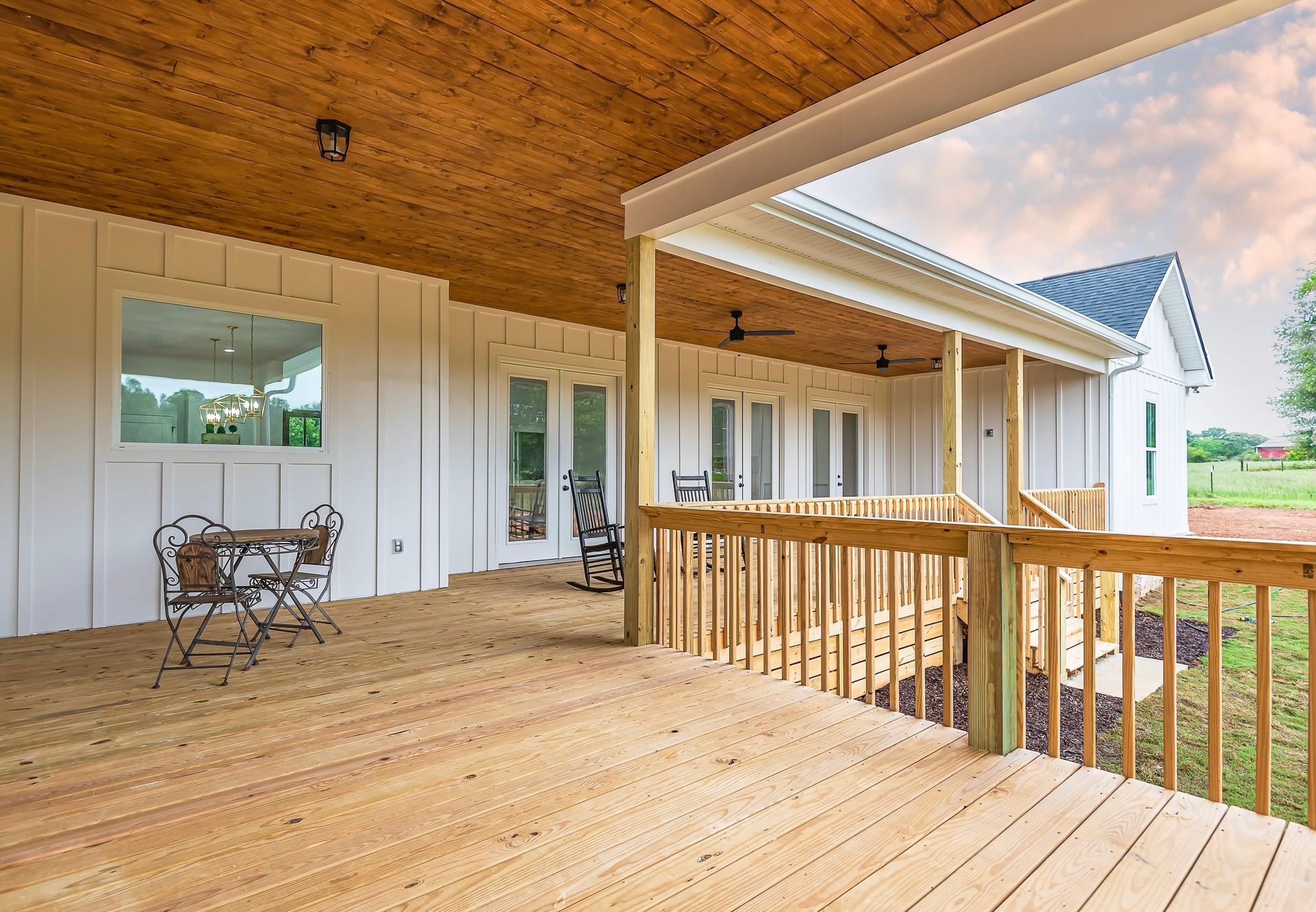 There is a large wooden deck with a table and chairs on it.