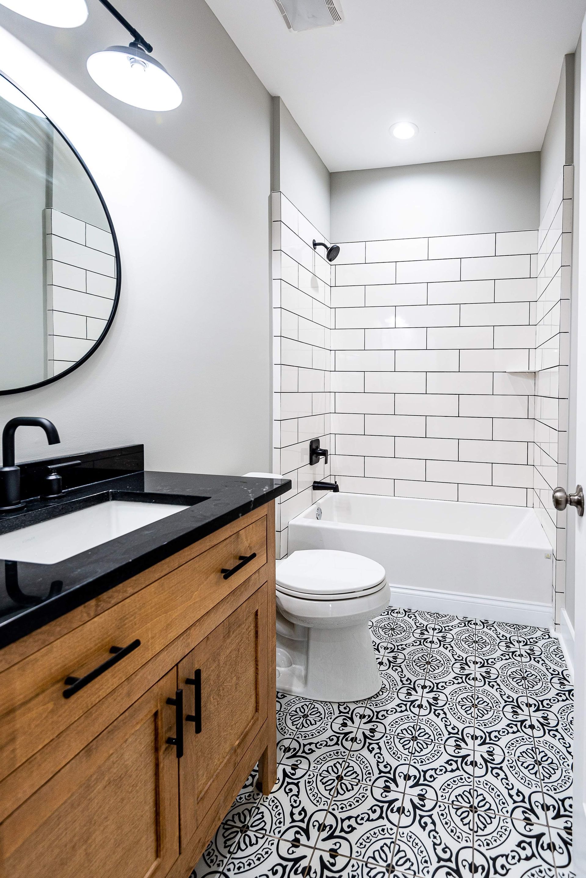 A bathroom with a sink , toilet , bathtub and mirror.