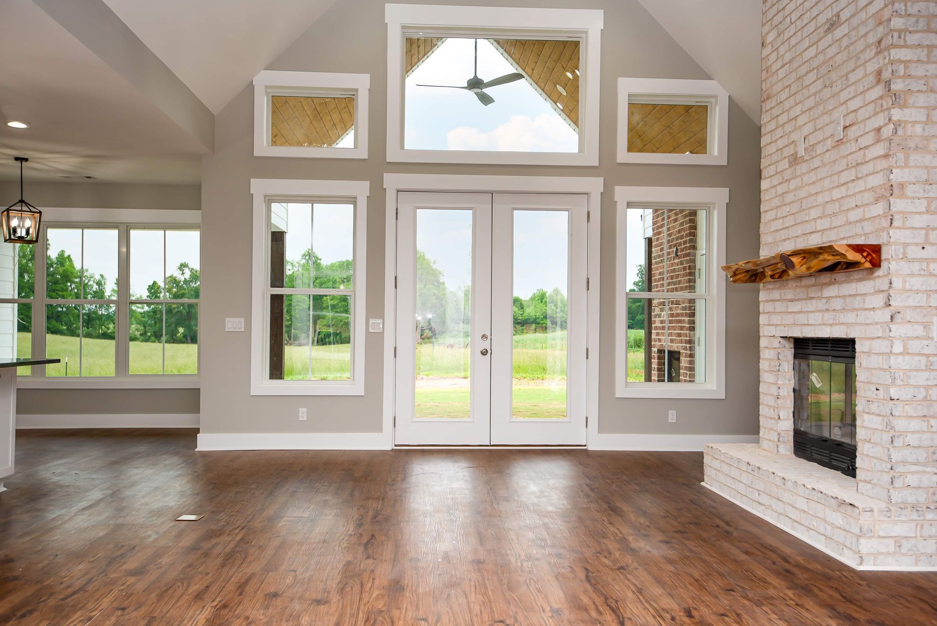 An empty living room with hardwood floors and a fireplace.