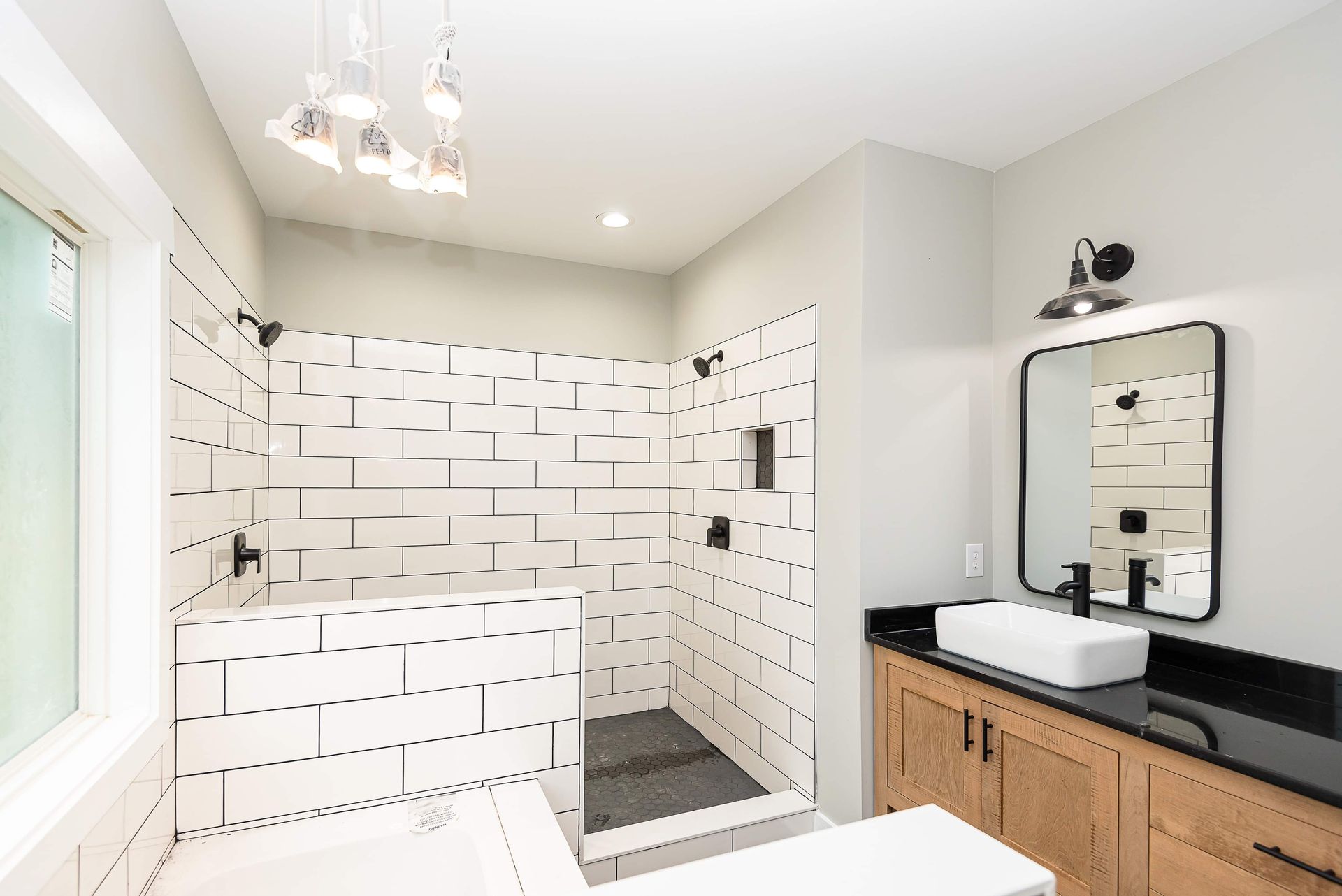A bathroom with a walk in shower , sink and mirror.