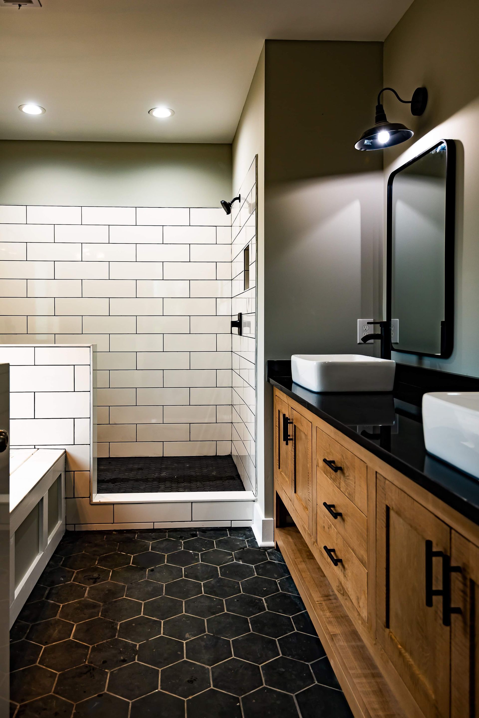 A bathroom with a walk in shower , sink and mirror.