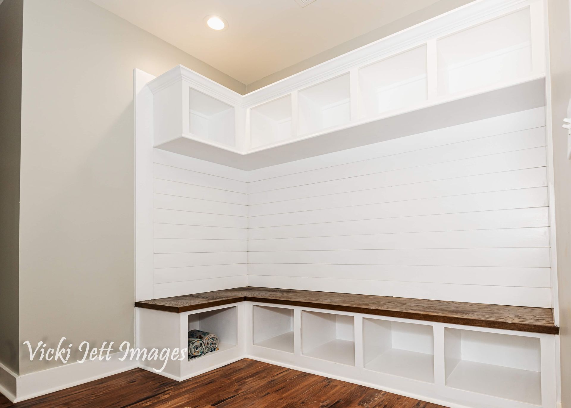 A corner of a room with a bench and shelves.