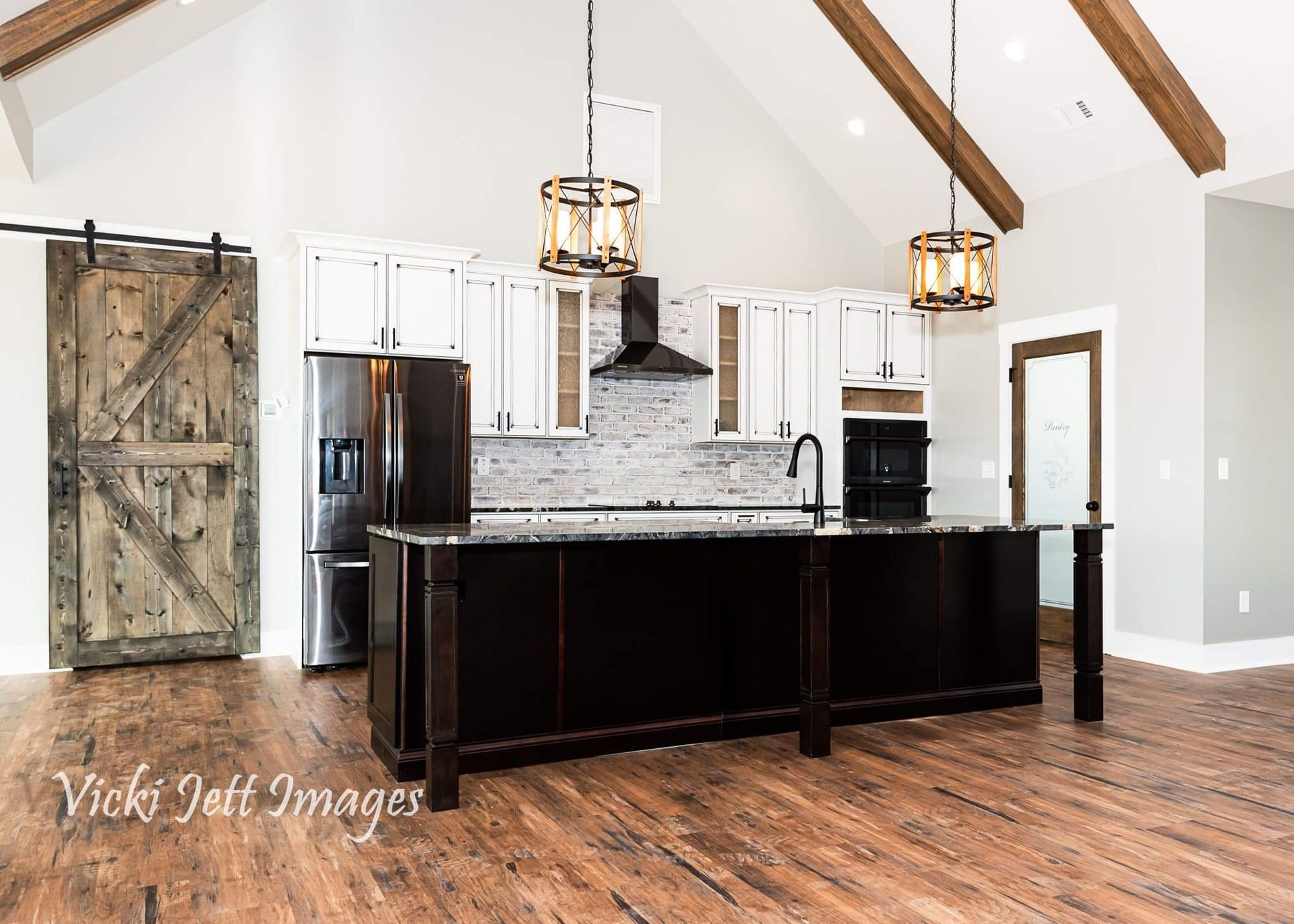 A kitchen with a large island and a sliding barn door.