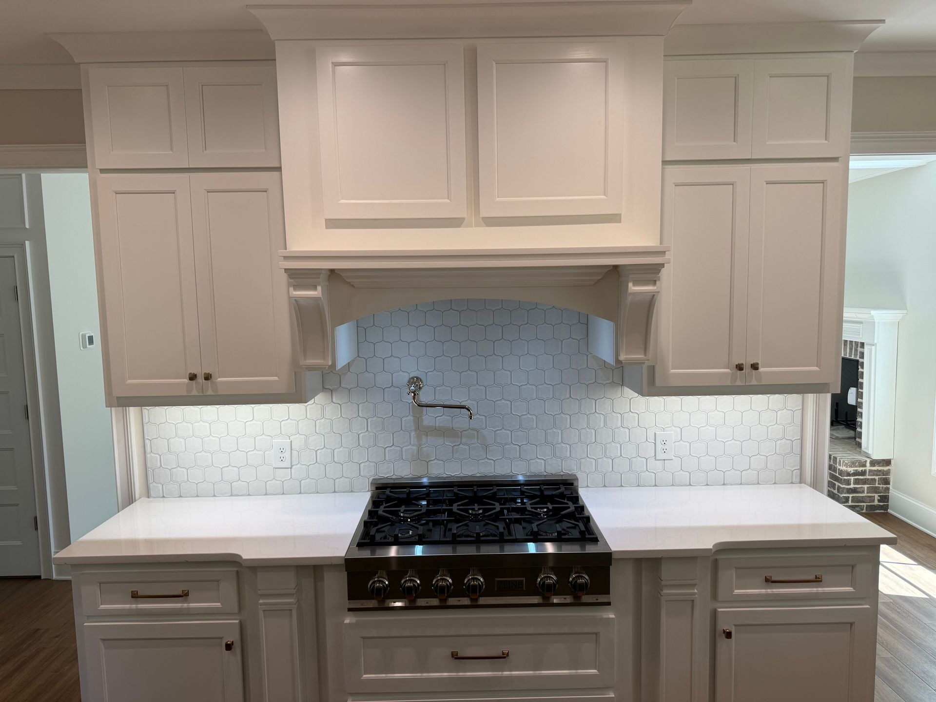 A kitchen with white cabinets and a stove top oven