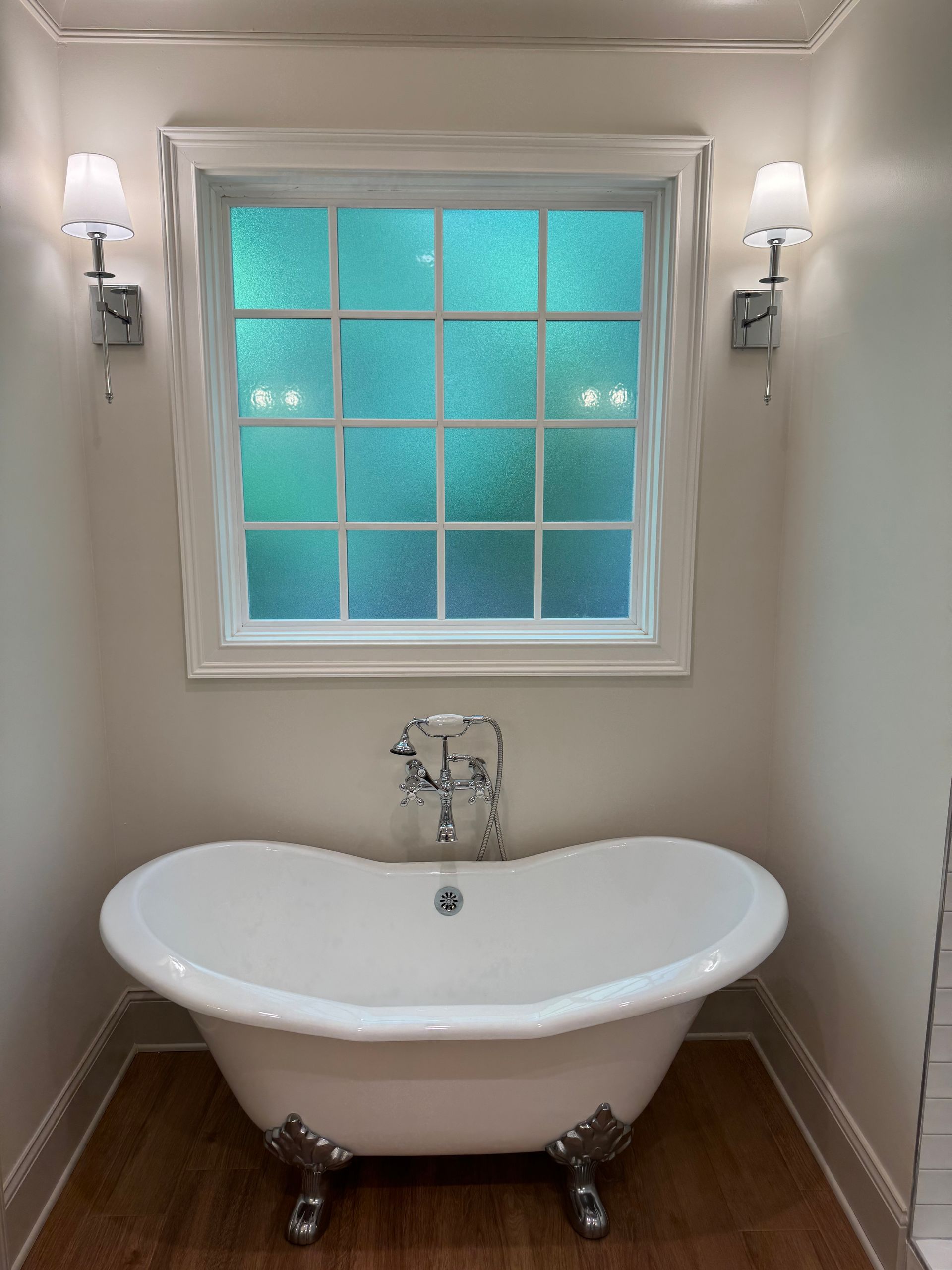 A bathroom with a bathtub and a window.