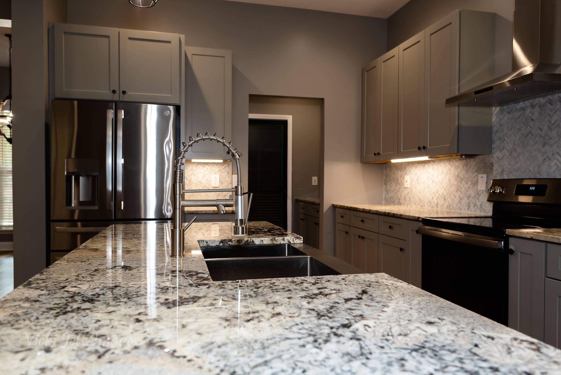 A kitchen with granite counter tops and stainless steel appliances.