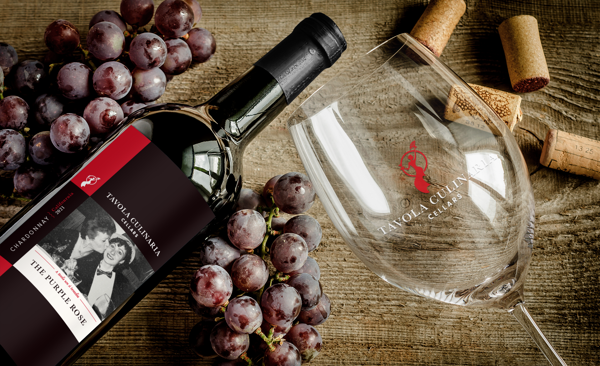 Wine bottle and glass with grapes on a wooden surface.