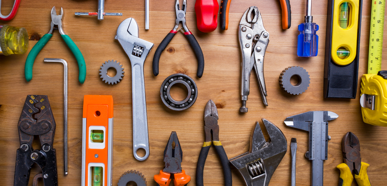 An air conditioning condenser sits outside on a concrete patio next to a brick building with a door and a window.