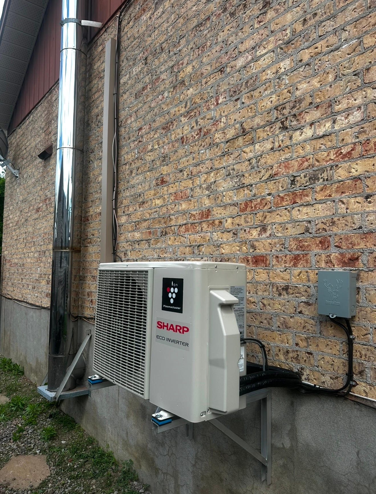 Un climatiseur blanc est monté sur le côté d'un bâtiment en briques.