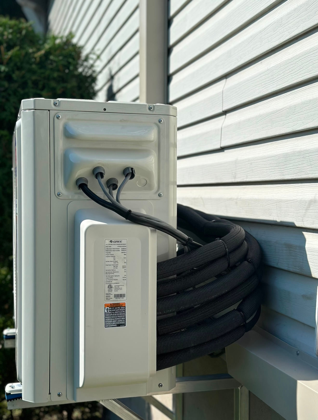 Un climatiseur blanc est fixé sur le côté d'une maison.