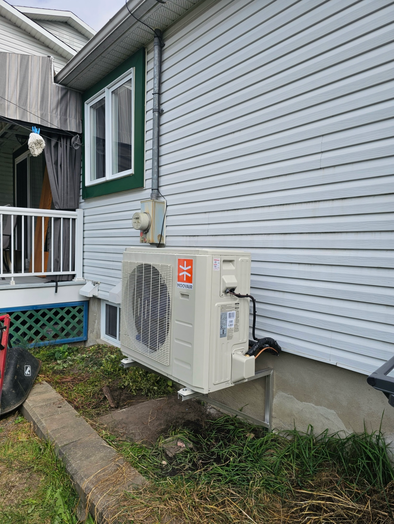 Un grand climatiseur est monté sur le côté d'une maison.