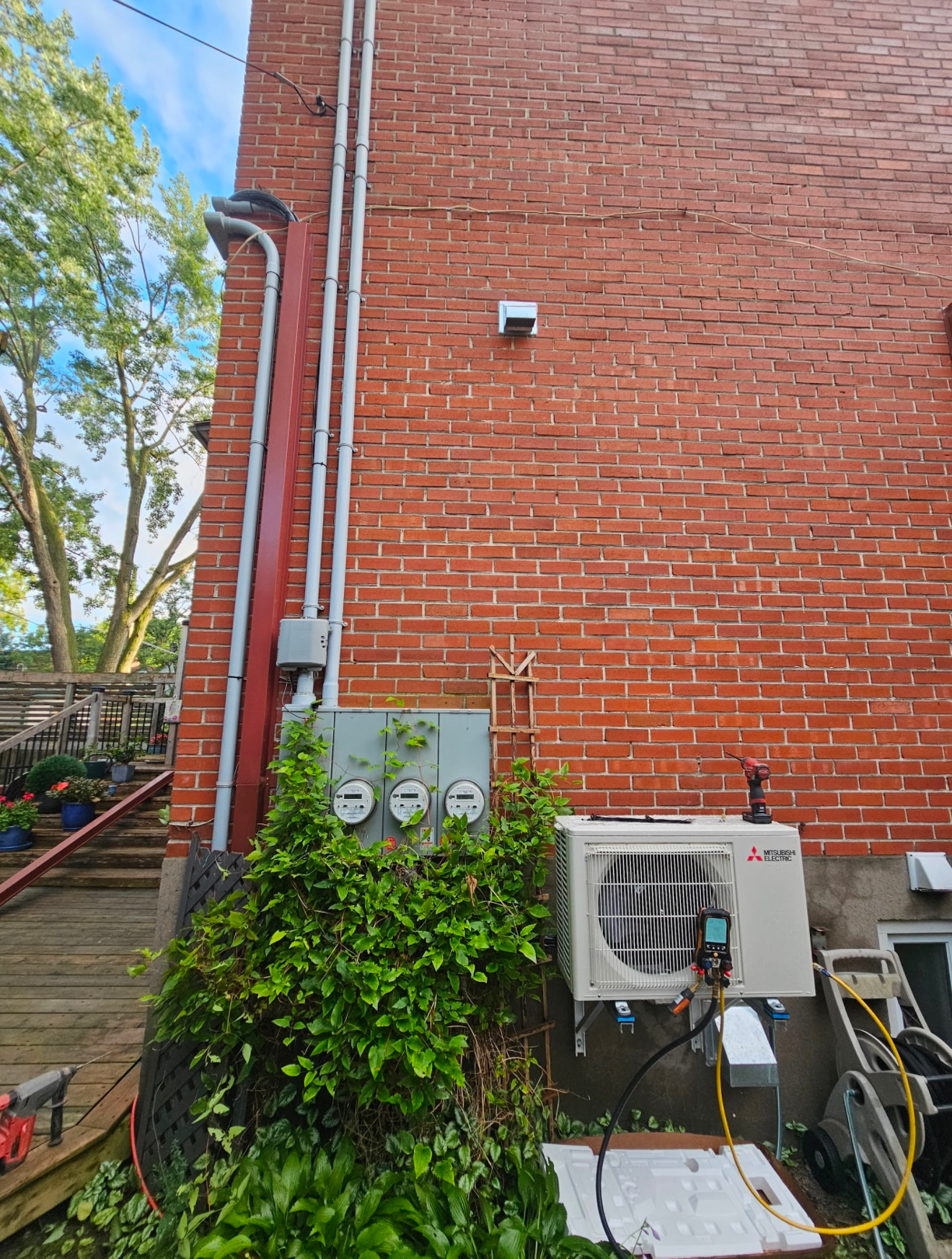 Un climatiseur blanc est posé sur le côté d'un bâtiment en briques.