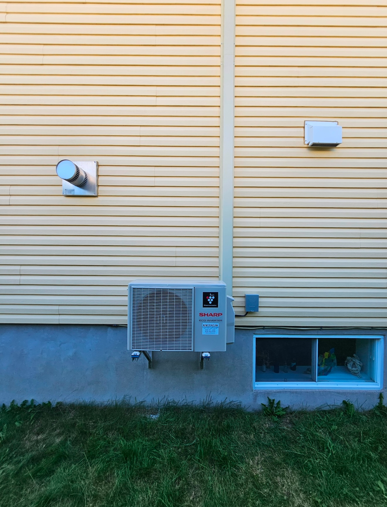 Un climatiseur blanc est monté sur le côté d'une maison.