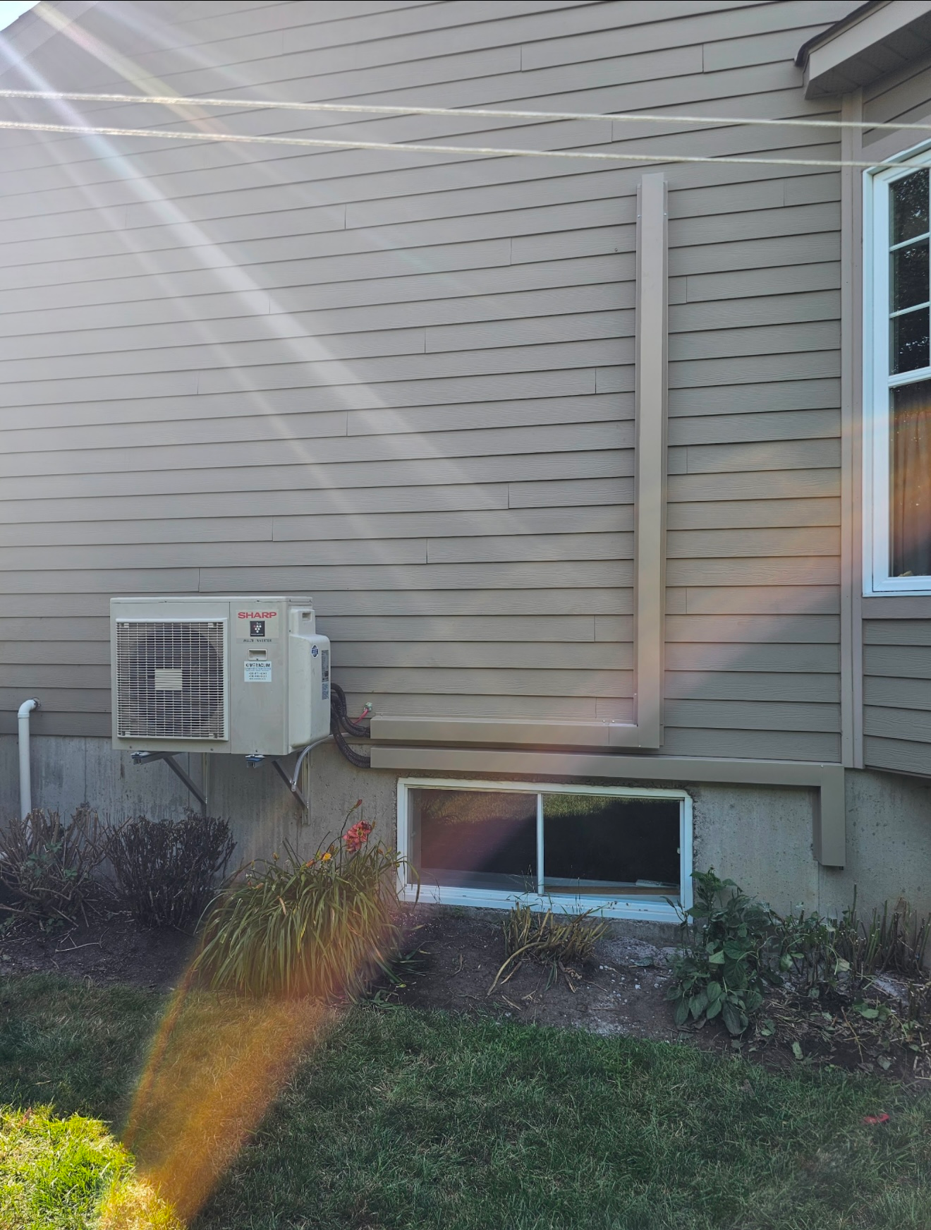 Une maison avec une fenêtre et un climatiseur sur le côté.