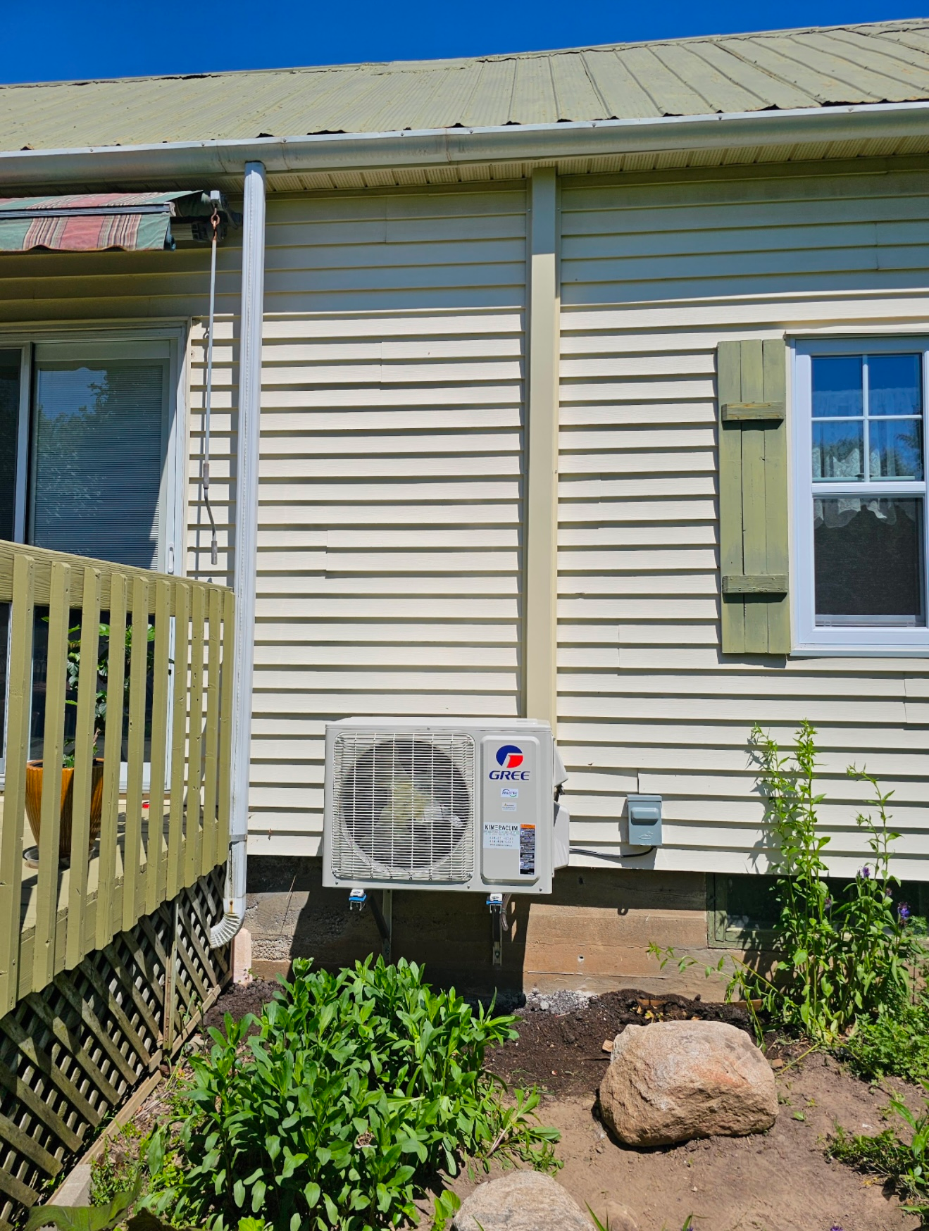 Une maison blanche avec un climatiseur blanc sur le côté