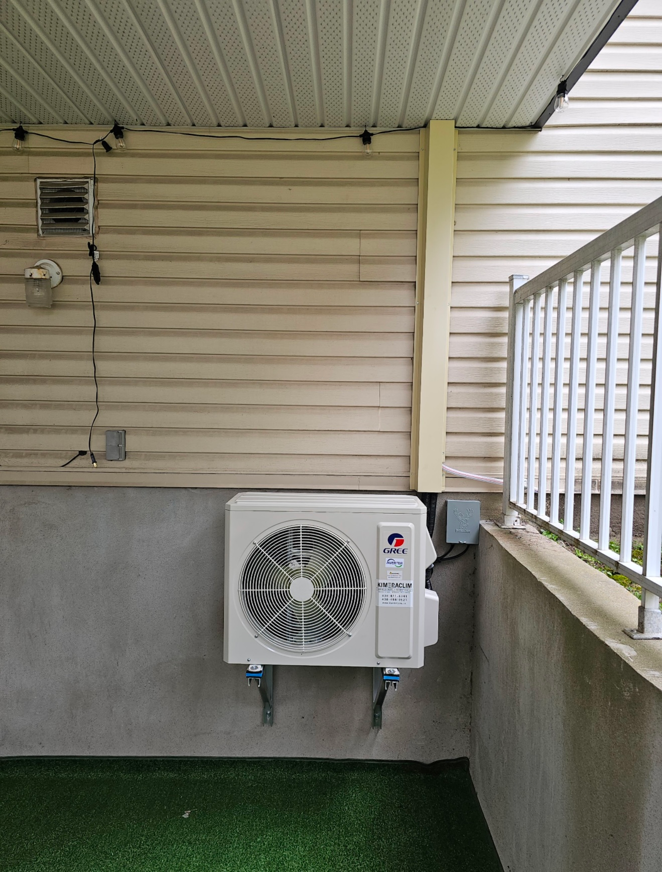 Un climatiseur blanc est monté sur le côté d'une maison.