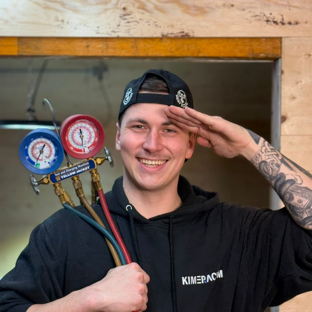 Un homme portant un sweat à capuche noir sur lequel est écrit kinepack