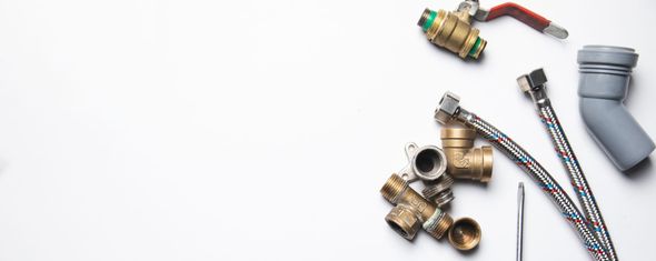 Plumbing tools arranged on a white surface.