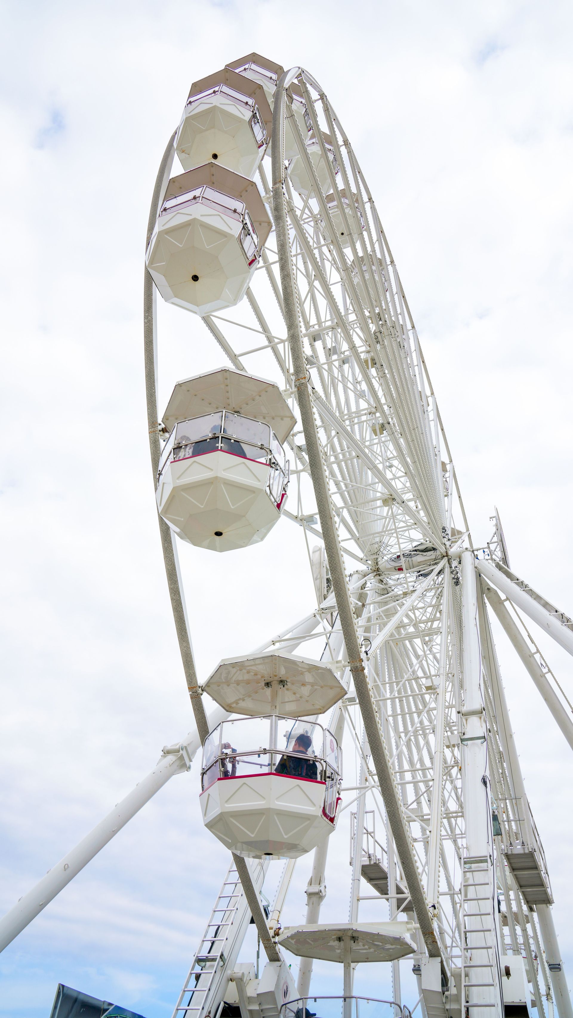 A large white ferris wheel with a blue sky in the background.