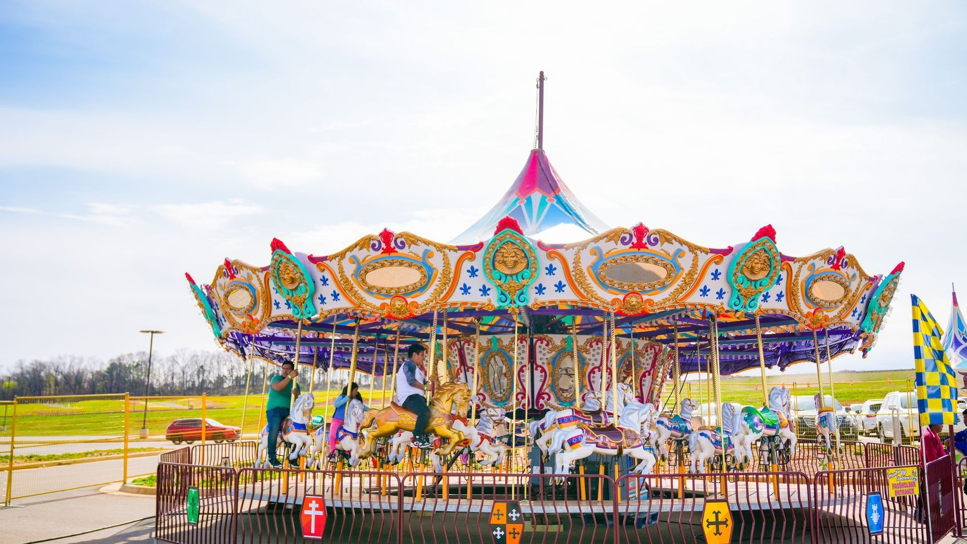 A carousel at an amusement park on a sunny day.