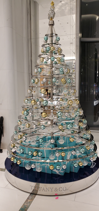 Tiffany & Co. Christmas tree display with blue and gold ornaments, set on a blue base and silver trim.