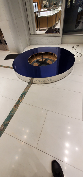 Circular blue and silver structure on a tiled floor, possibly a display, with 