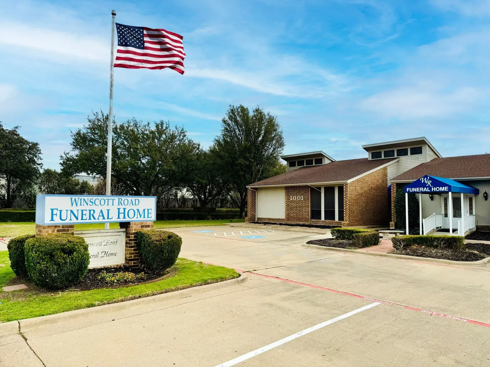 A large white building with a brown roof and a lot of windows.