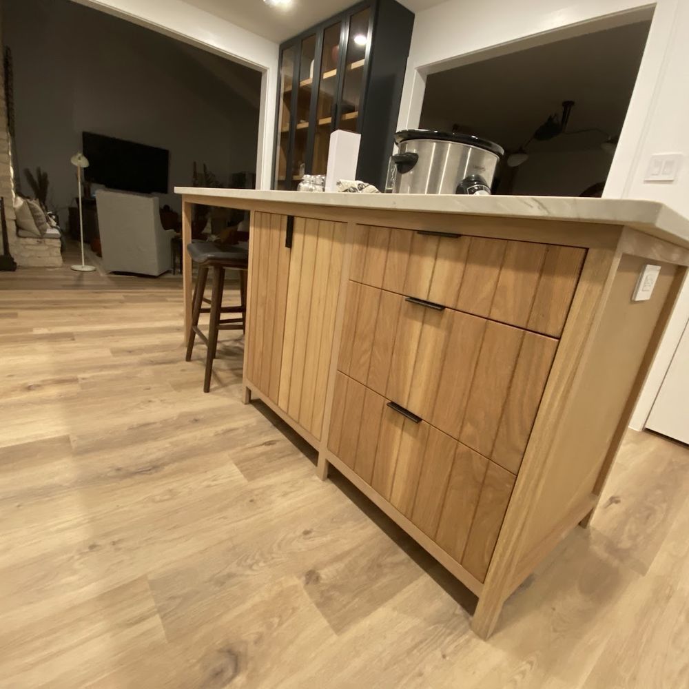 Wooden kitchen island with drawers and a countertop. A slow cooker sits on top.