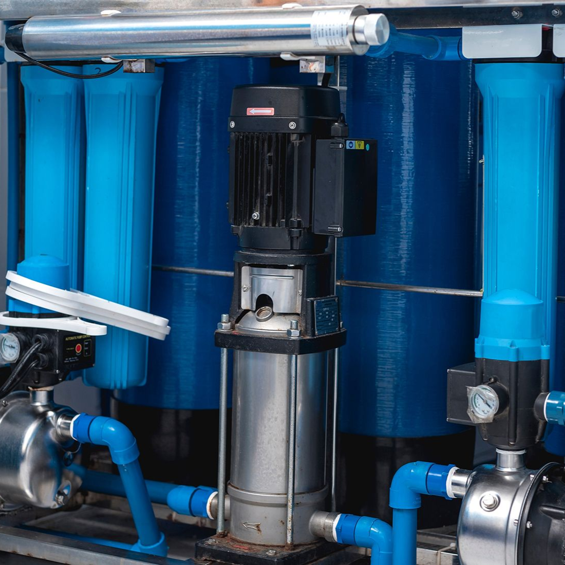 Water filtration system with blue filters, tanks, and a pump.