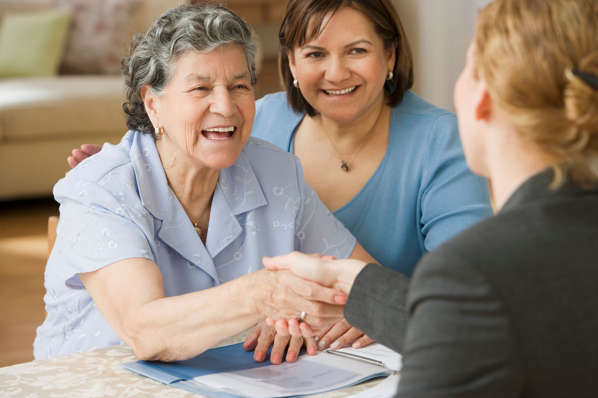 Senior Hispanic woman shaking hands with businesswoman