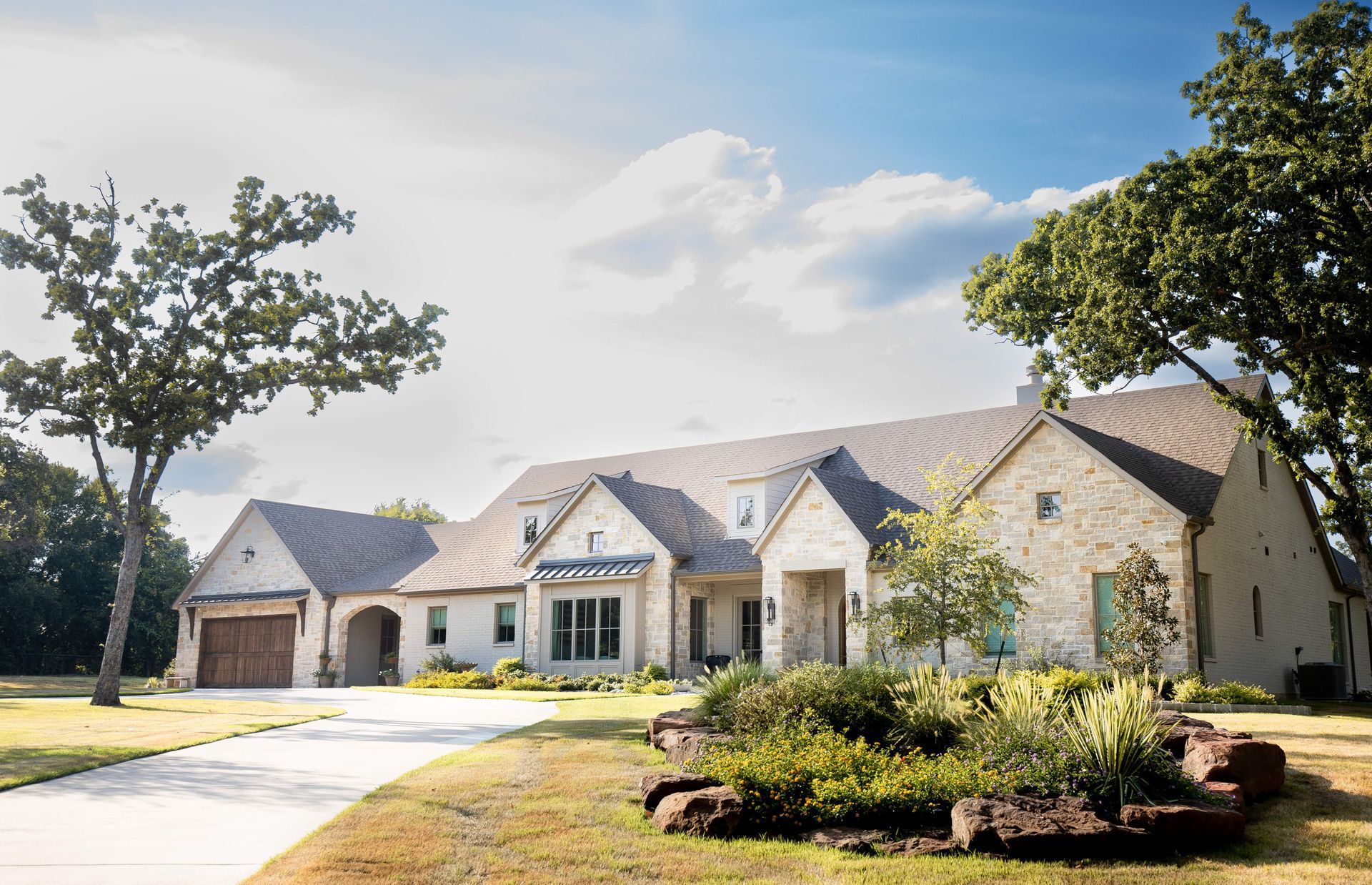 A large white house with a black roof and a driveway