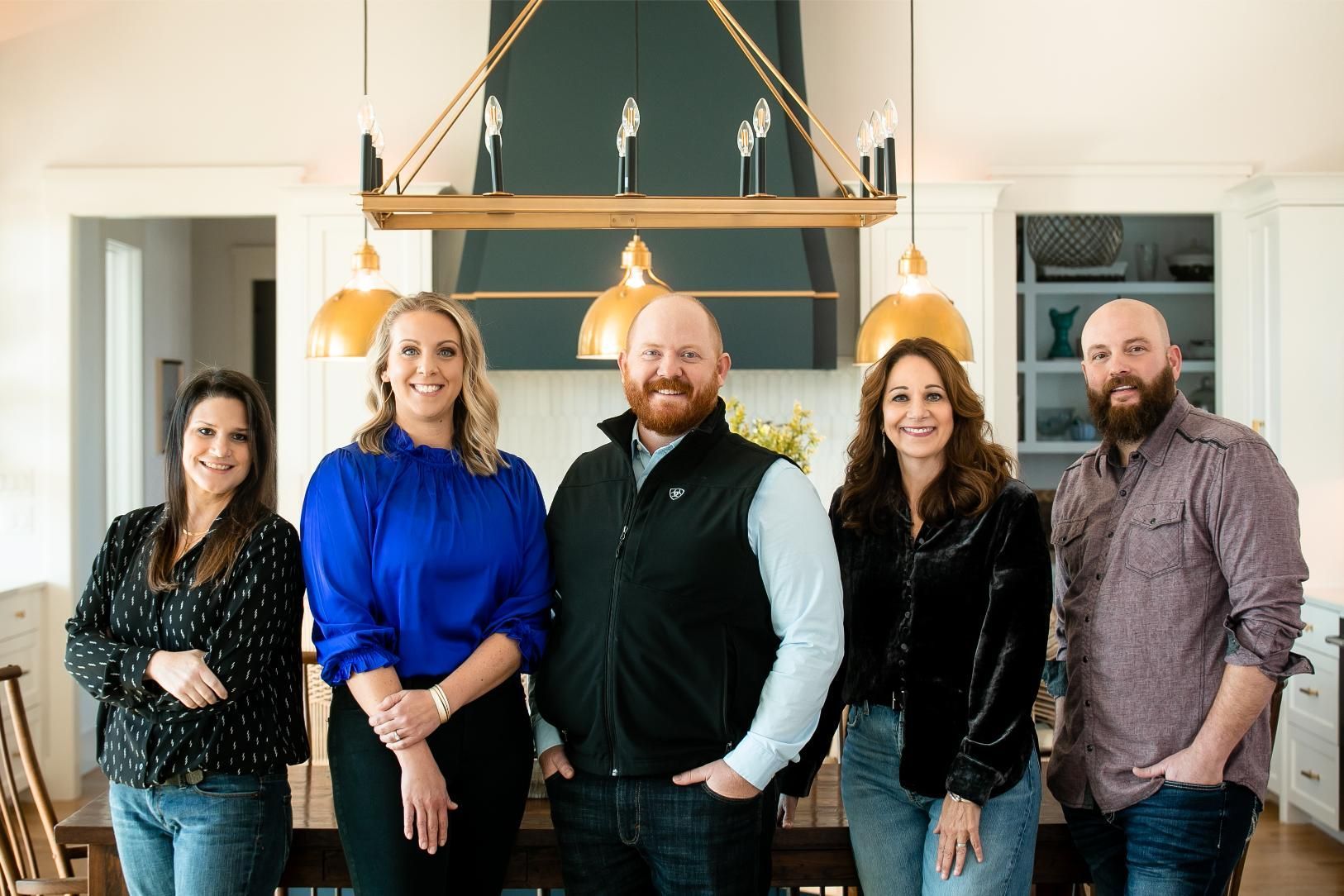 A group of people are posing for a picture in a kitchen.