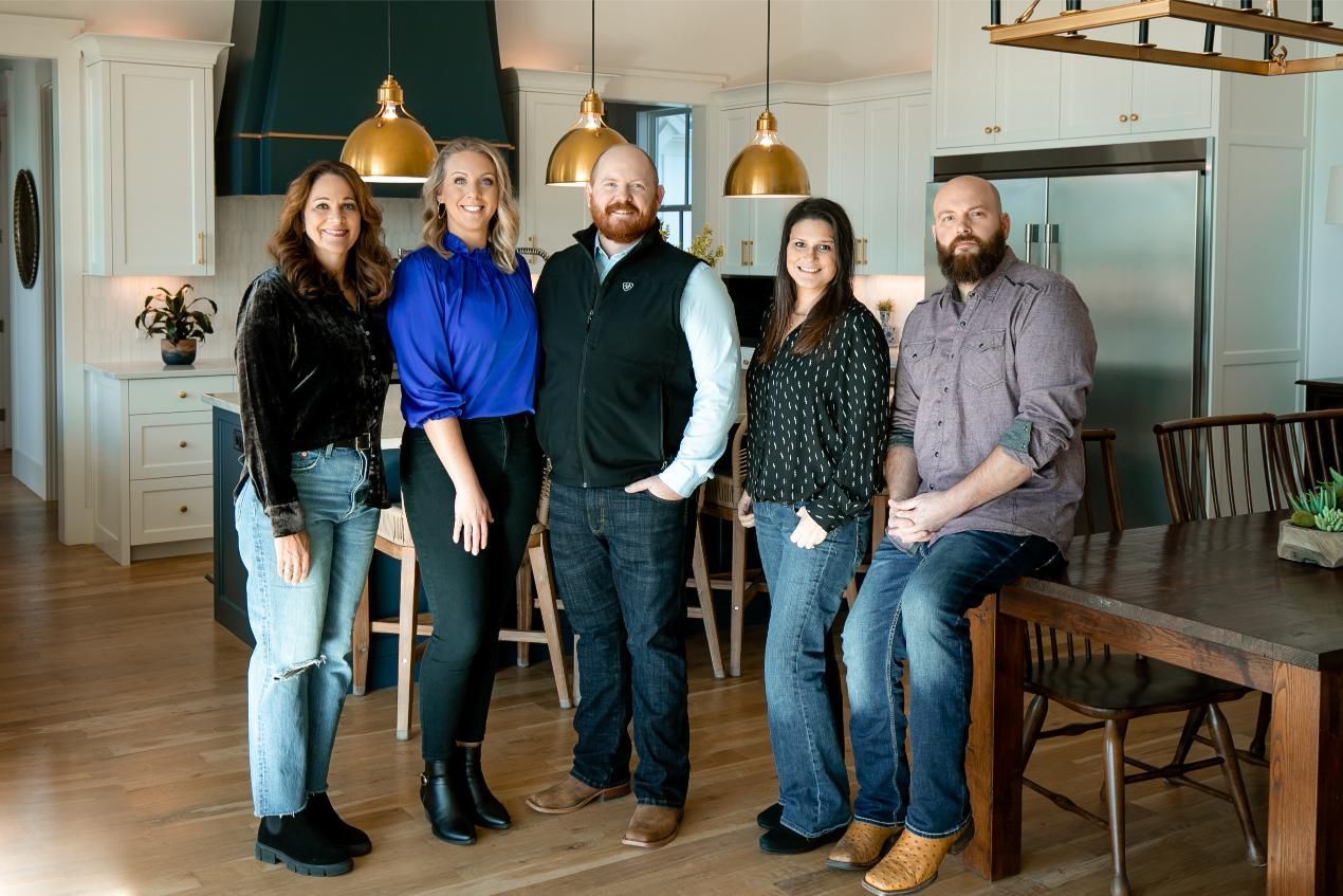 A group of people are posing for a picture in a kitchen.