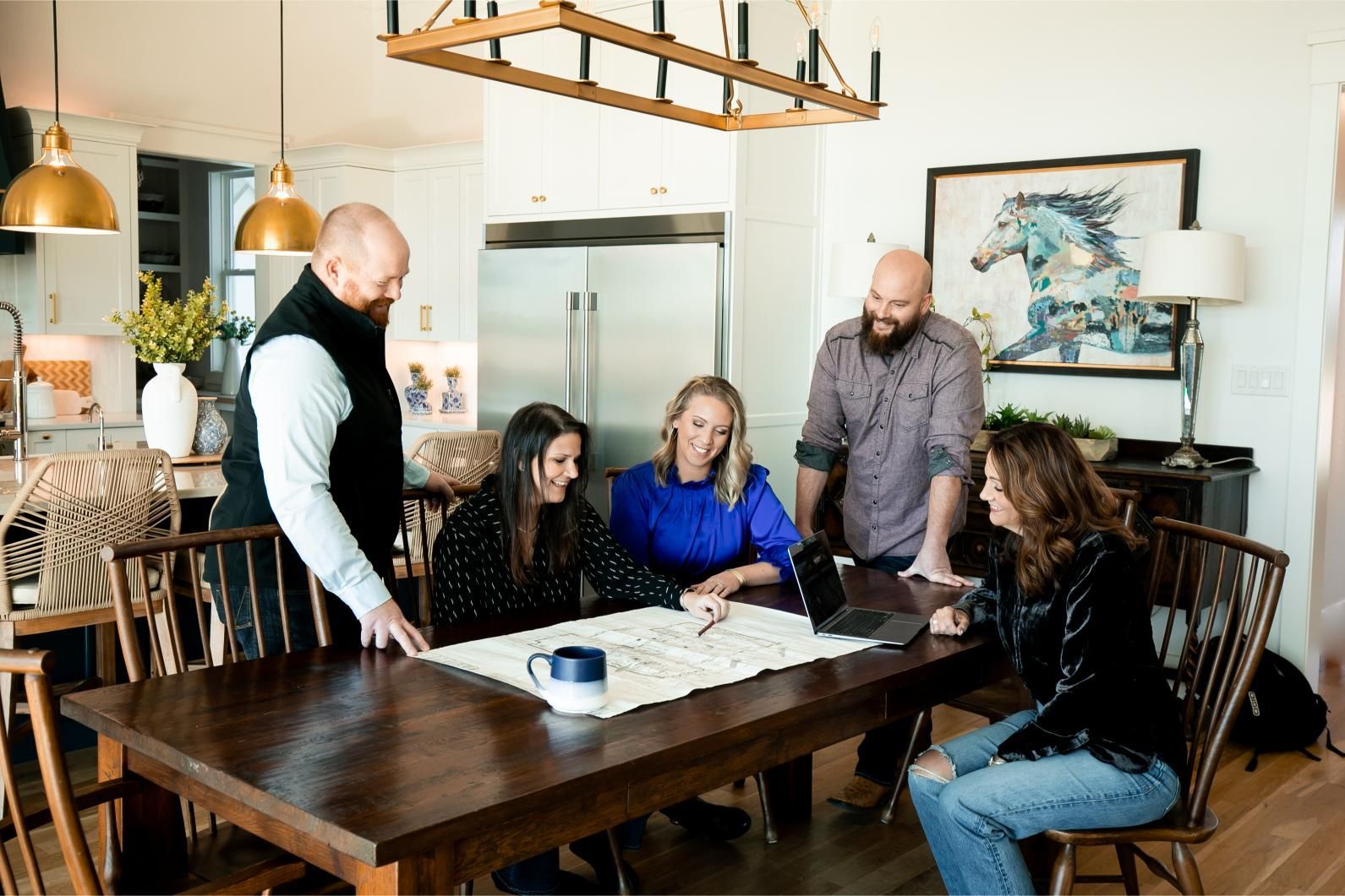 A group of people are sitting around a table in a living room.