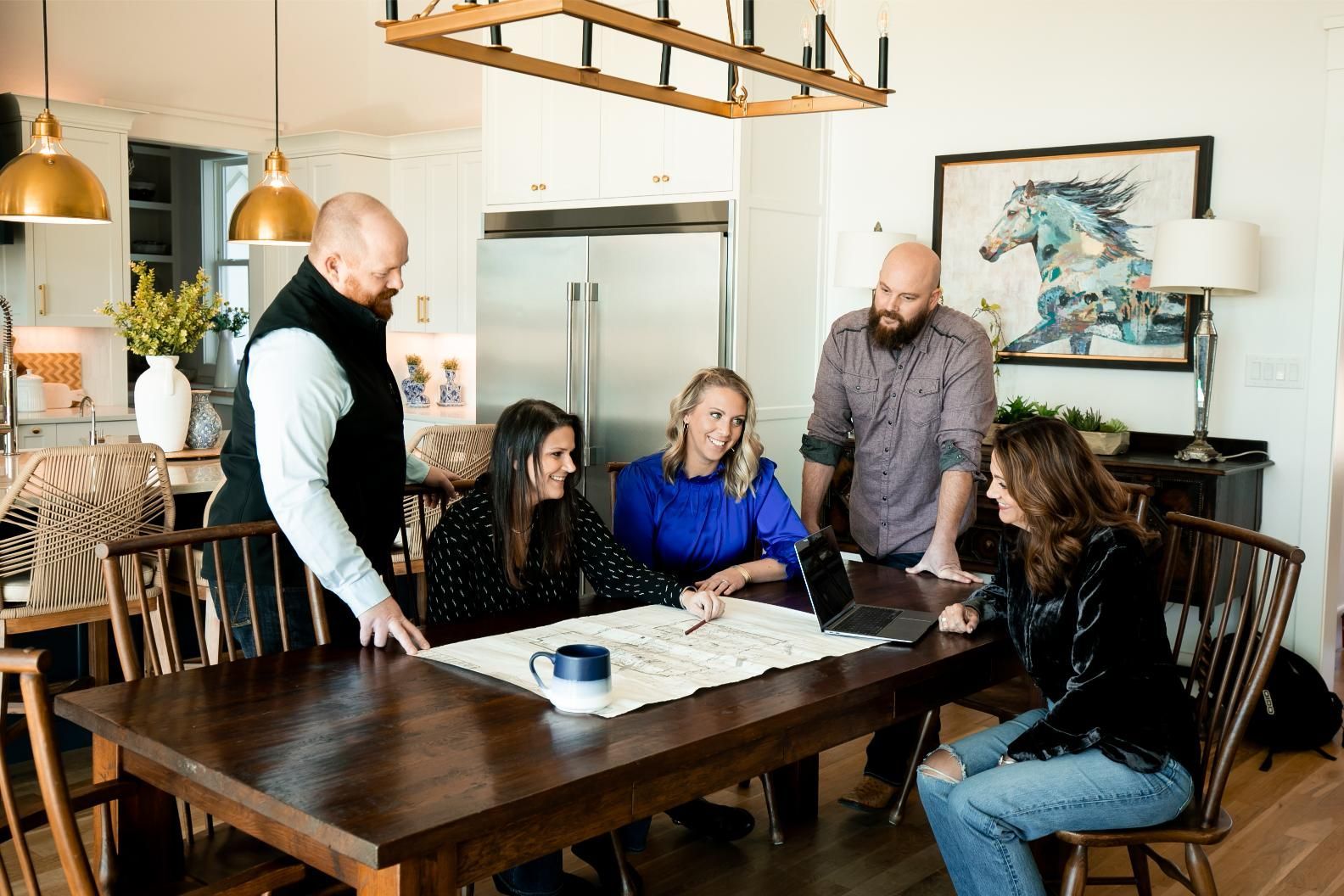 A group of people are sitting around a table in a living room.