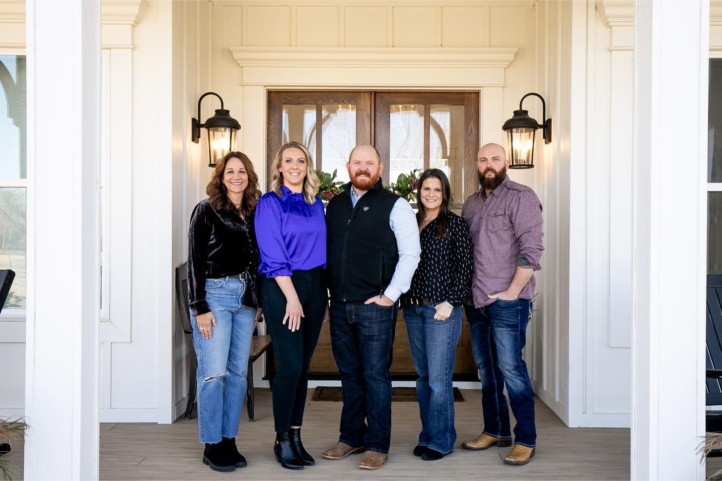A group of people are posing for a picture in front of a house.